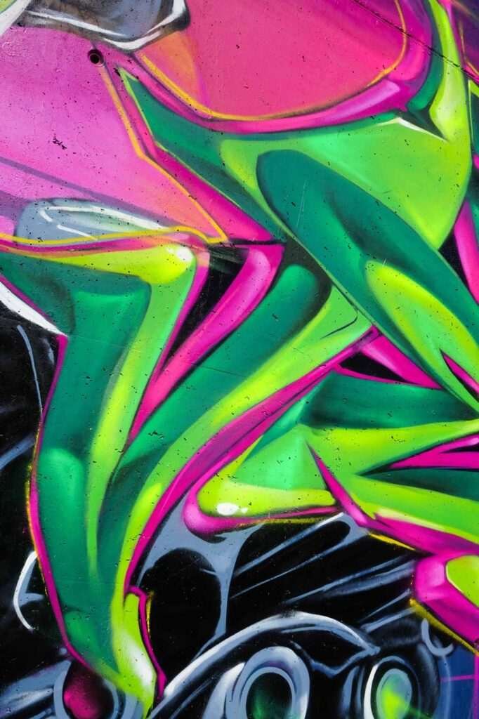 Mural de La Máscara estilo graffiti con fondo rosa y verde