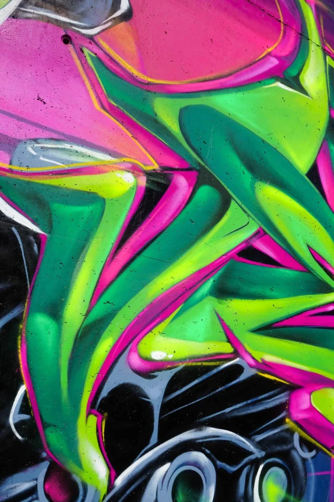 Mural de La Máscara estilo graffiti con fondo rosa y verde