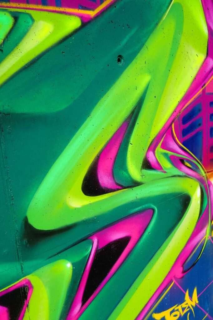 Mural de La Máscara estilo graffiti con fondo rosa y verde