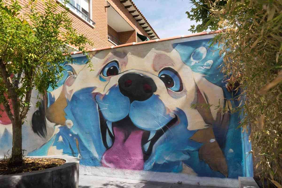 Mural con perros felices en fachada de clínica veterinaria en Toledo