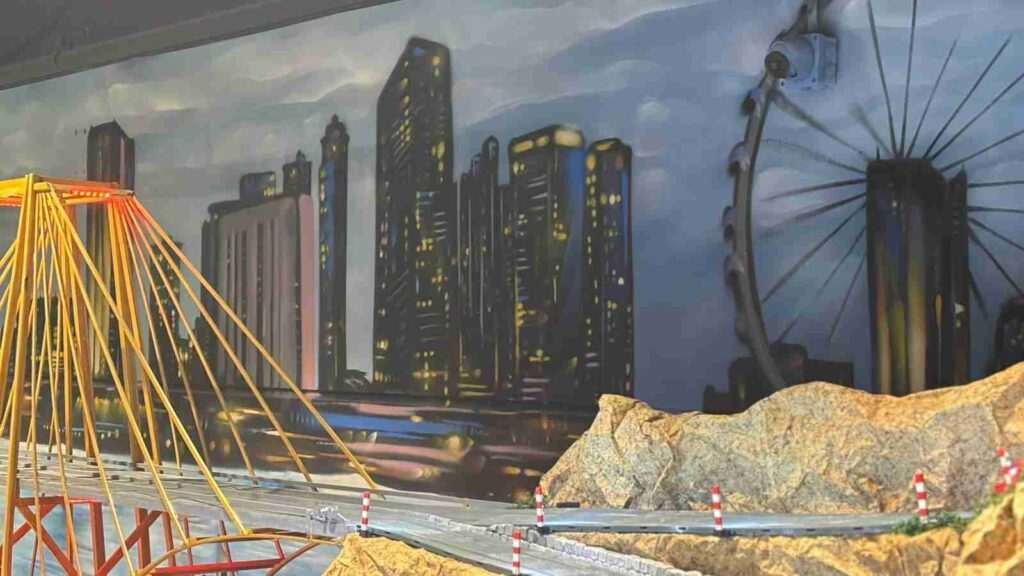 Mural de paisaje urbano para oficinas de GALA Autoescuela alrededor de una maqueta de Scalextric