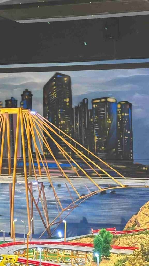 Detalle del puente amarillo y skyline nocturno del mural interior de GALA Autoescuela