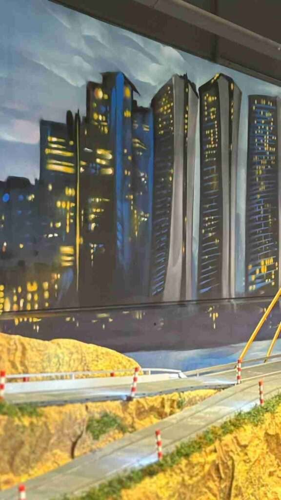 Detalle de rascacielos iluminados en el mural de paisaje urbano de GALA Autoescuela