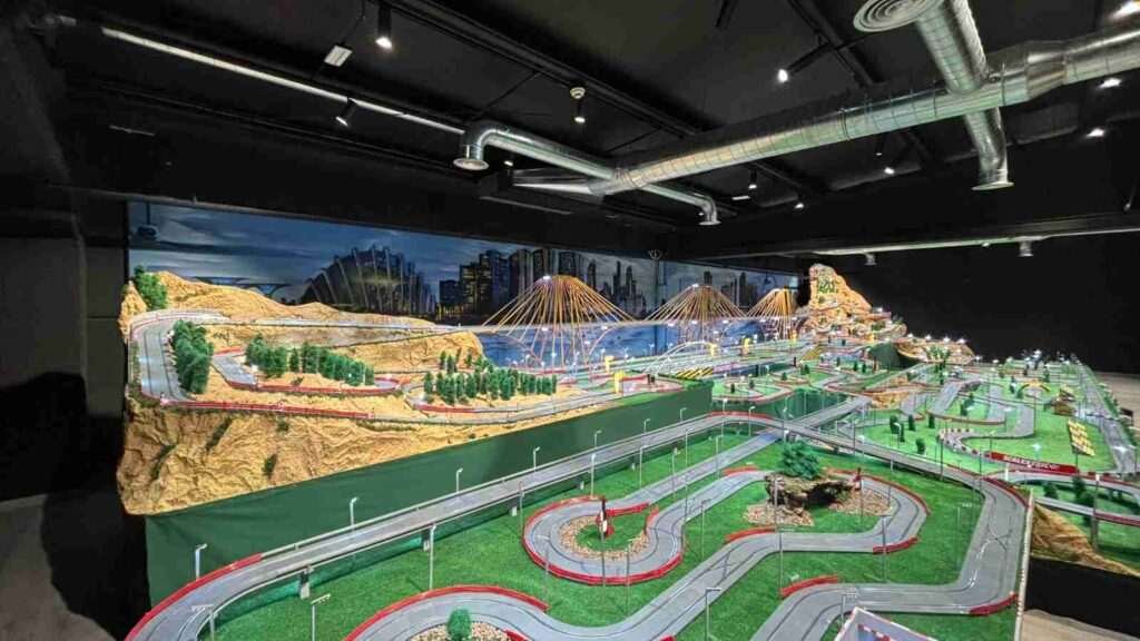 Oficinas de GALA Autoescuela con mural interior de ciudad nocturna y circuito Scalextric