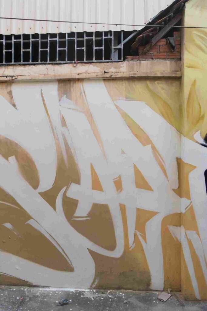 Mural graffiti en fachada de Camboya, retrato femenino con gorra para S’art Urban Art Festival.