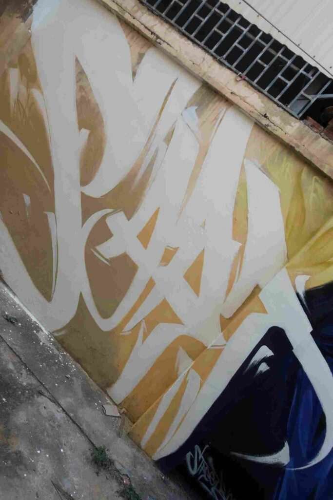 Mural graffiti en fachada de Camboya, retrato femenino con gorra para S’art Urban Art Festival.
