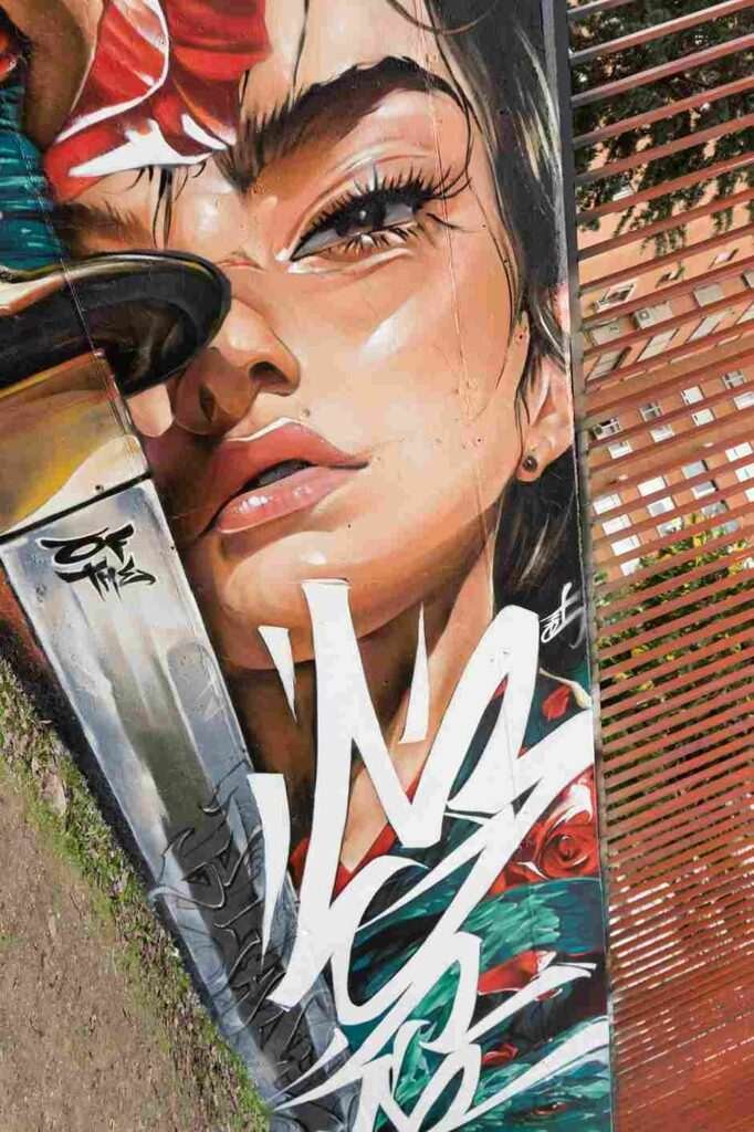 mural madrid the edge of the blade retrato femenino con rosas y serpiente tipografía graffiti blanca barrio del pilar