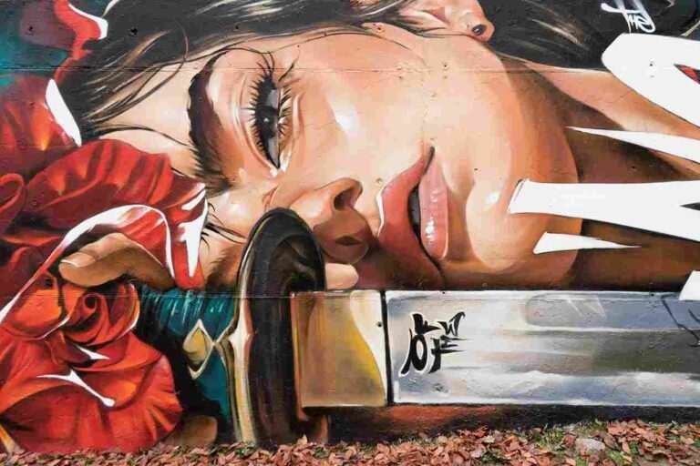 mural madrid the edge of the blade retrato femenino con rosas y serpiente tipografía graffiti blanca barrio del pilar