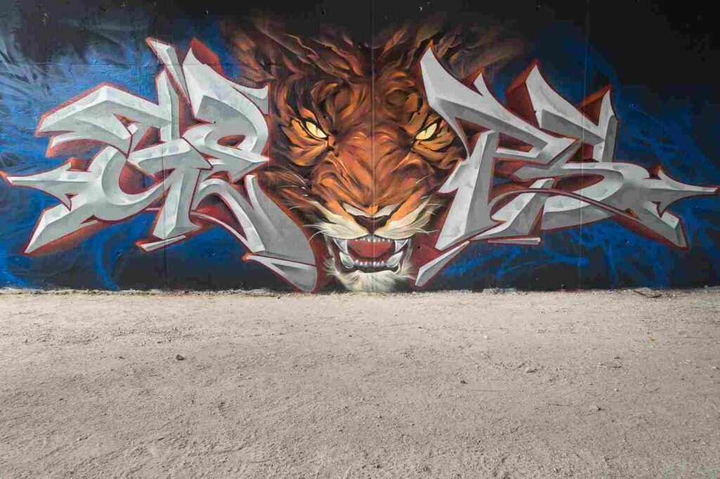 Mural graffiti de tigre frontal con lettering metálico a ambos lados