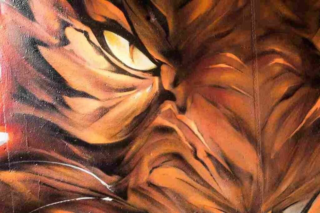 Textura del pelaje naranja y sombras del tigre en mural urbano