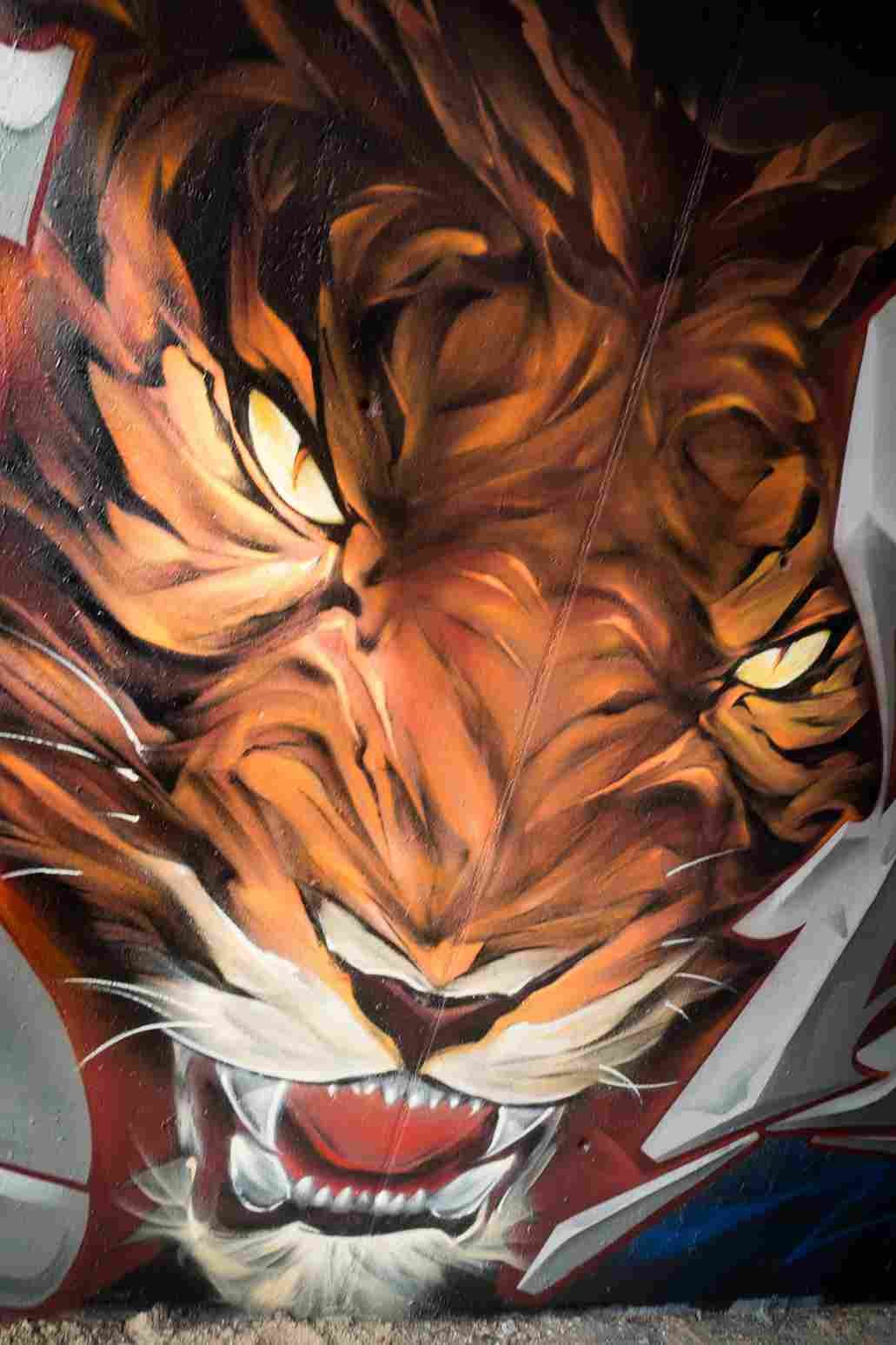 Perfil del rostro del tigre con iluminación cálida en mural 3D