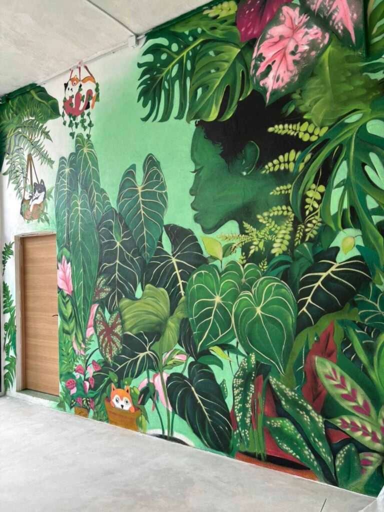 Mural decorativo para Plantukas en Cantabria con retrato femenino rodeado de hojas tropicales