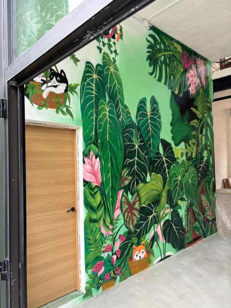 Mural de naturaleza en interior comercial de Cantabria con pared botánica y retrato femenino verde