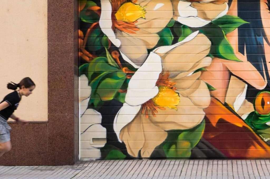 Detalle de flores blancas y naranjas en el mural de la princesa y la rana realizado en Salamanca