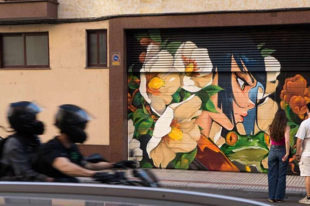 Vista frontal del mural La princesa y la rana en Salamanca, con cierre metálico convertido en obra urbana