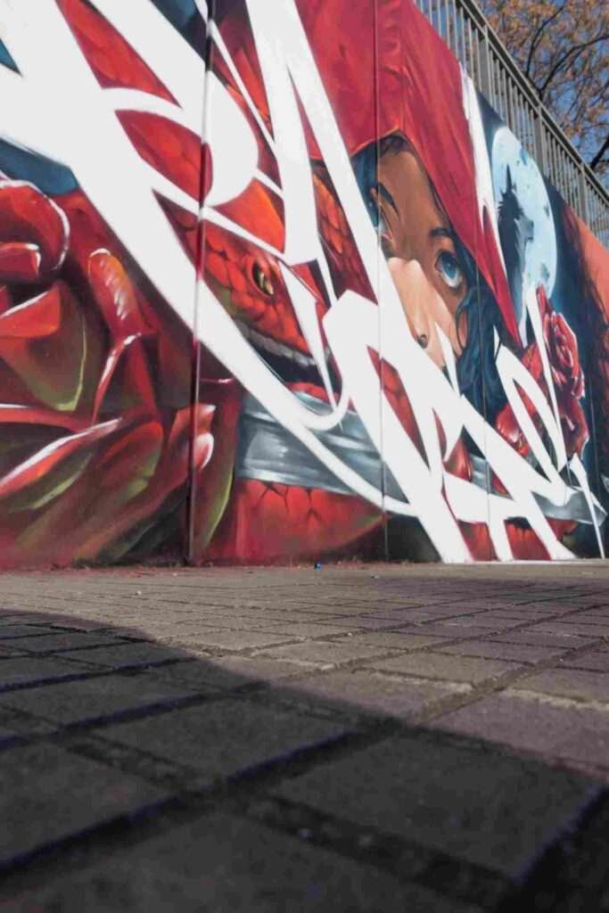Composición mural con serpientes, rosas rojas y graffiti lettering en Les Franqueses del Vallès