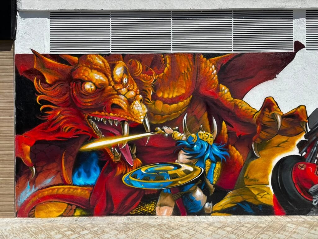 Dragón y guerrero con escudo azul y espada dorada en el mural de Akira Comics, Madrid