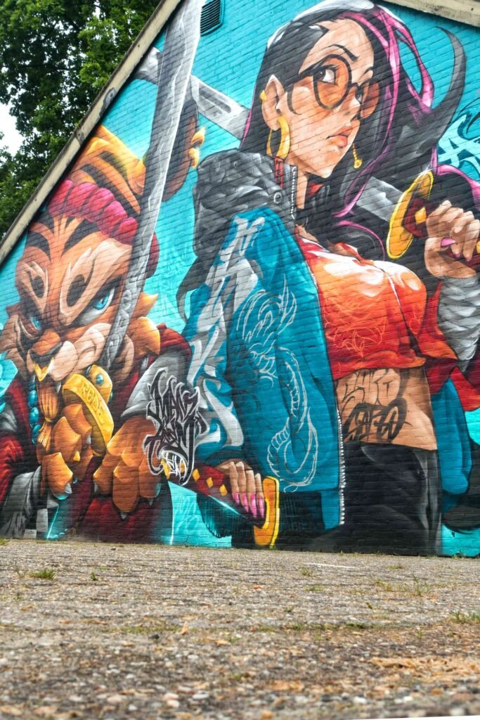 Guerrero tigre y chica manga con las katanas cruzadas en el centro del mural de Weert