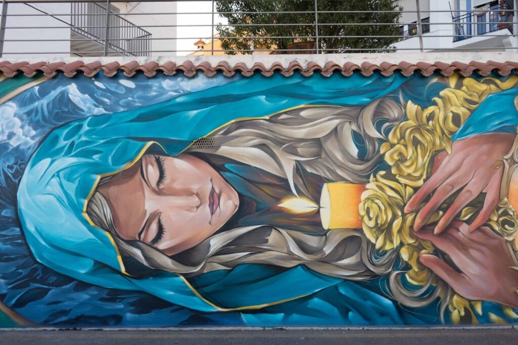 Figura de la Mare de Déu de la Candelera con velo azul, rosas doradas y una vela en el mural de l'Ametlla