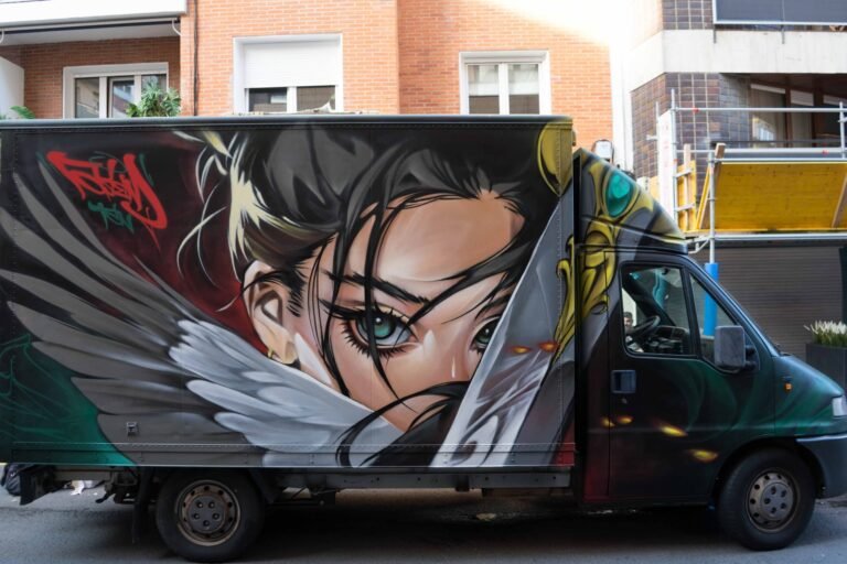 Graffiti en camión en Algorta: chica anime de ojos turquesa con alas de plumas en el lateral de la caja