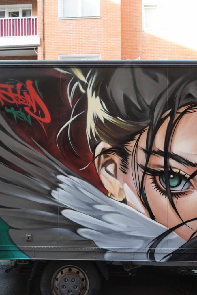 Detalle de las alas de plumas grises del graffiti en camión de Algortagraff 2026