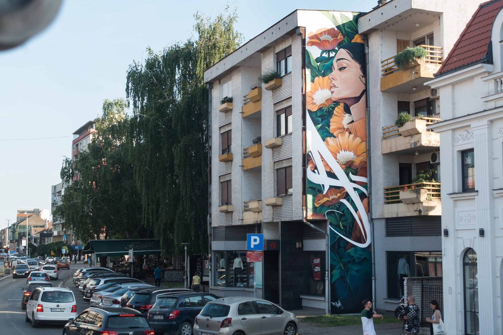 Mural de mujer con flores en Bijeljina (Bosnia): Aroma, de Asem Navarro, en la fachada de un edificio de viviendas