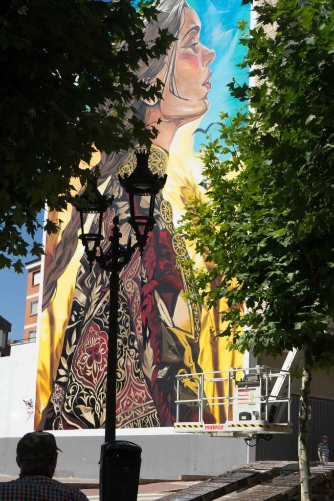 El mural Casilda asoma entre los árboles de la calle en Briviesca (Burgos)