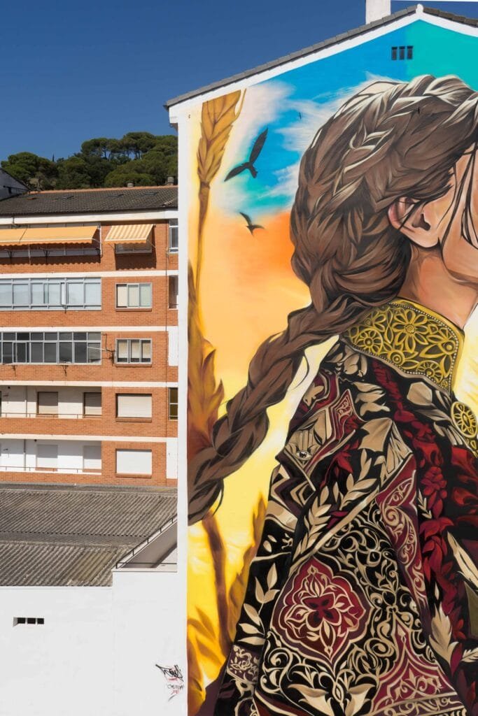 Detalle del mural Casilda: chaqueta de cuello dorado con bordado granate y oro y la trenza larga