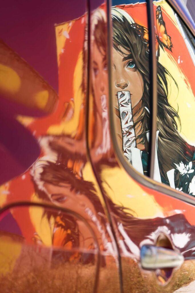 El mural Muda de Fanzara reflejado en la chapa de un coche aparcado
