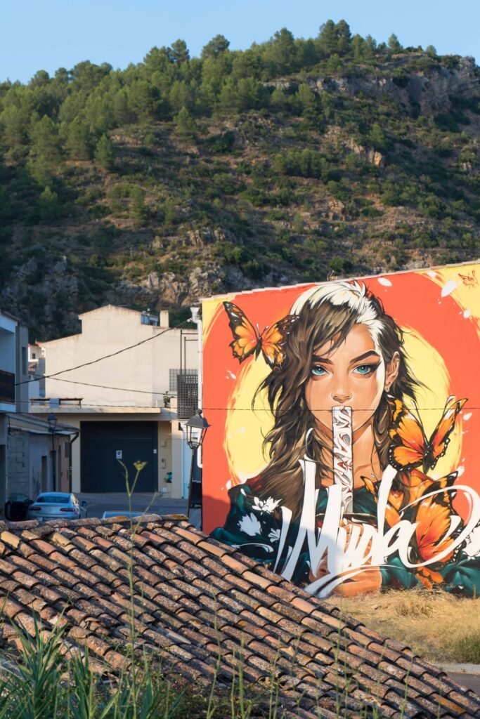 Vista del mural Muda sobre los tejados de Fanzara con el monte al fondo