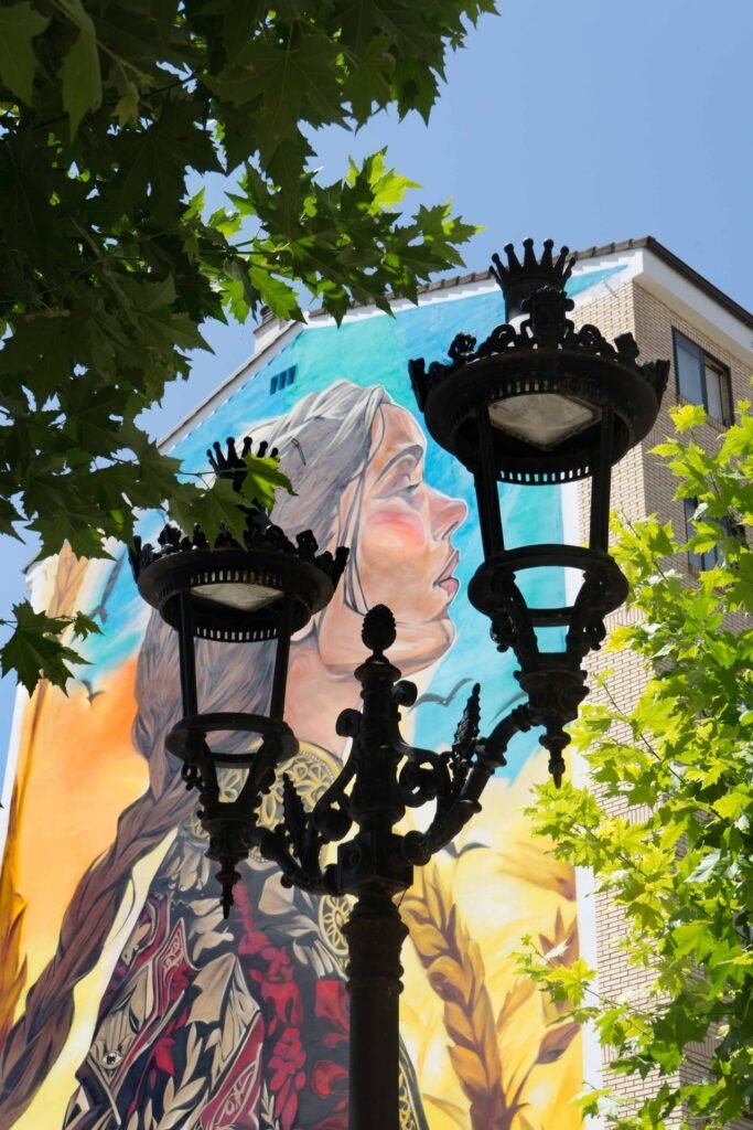 Mural de Santa Casilda en Briviesca visto tras una farola de fundición con remate de corona