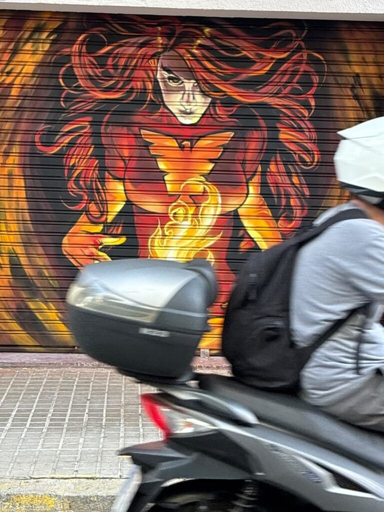 Detalle del fuego y el emblema en el graffiti de la persiana de Estudio Fénix