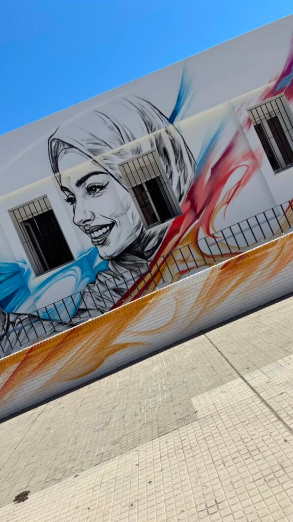 Retrato de mujer con hiyab en el mural de la fachada del Hogar Betania