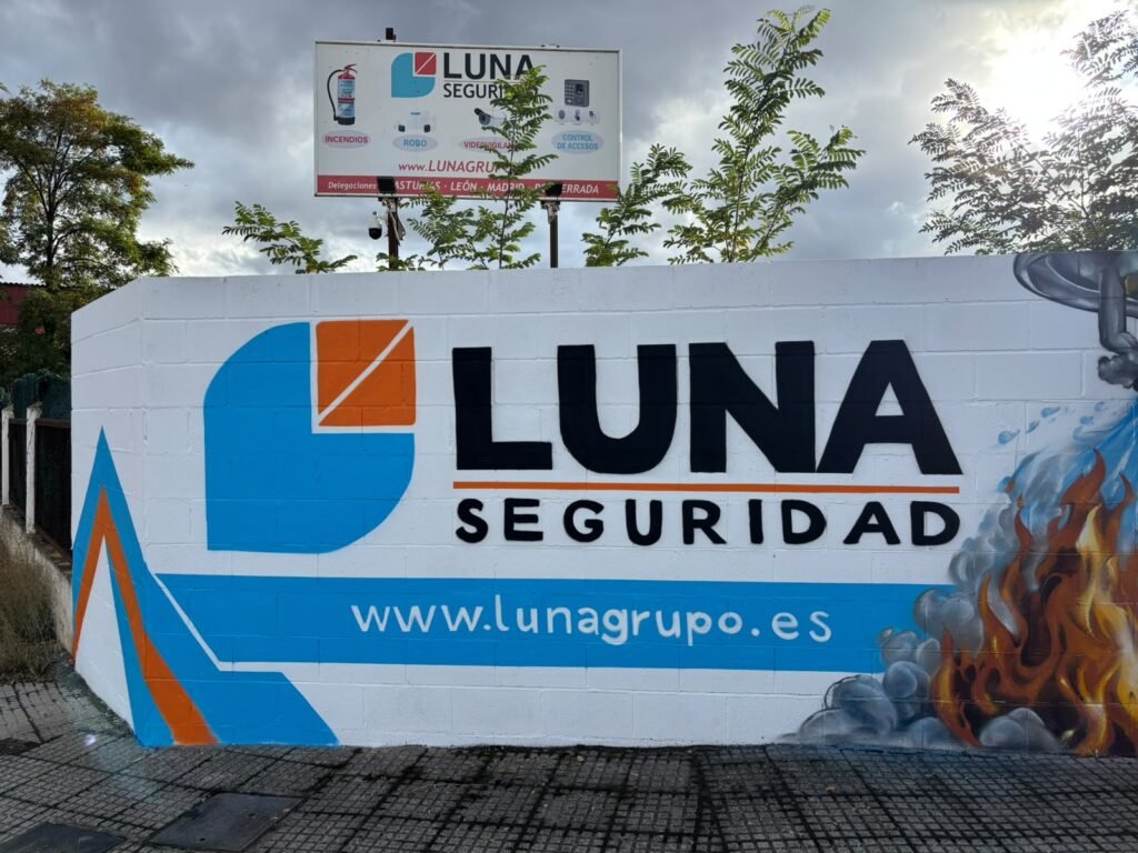 Logotipo de Luna Seguridad pintado a mano en el muro de su sede de León