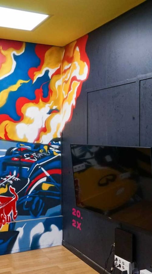 Graffiti de Red Bull con F1 y llamas en espacio interior, mural con energía y acción