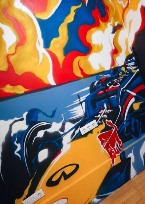 Graffiti de Red Bull con F1 y llamas en espacio interior, mural con energía y acción