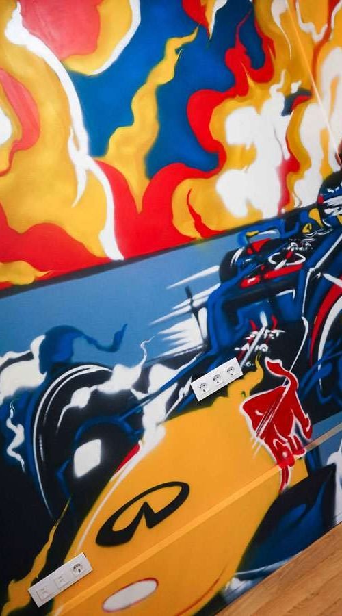 Graffiti de Red Bull con F1 y llamas en espacio interior, mural con energía y acción