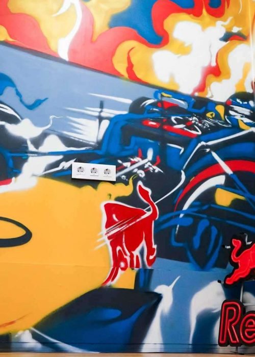 Graffiti de Red Bull con F1 y llamas en espacio interior, mural con energía y acción
