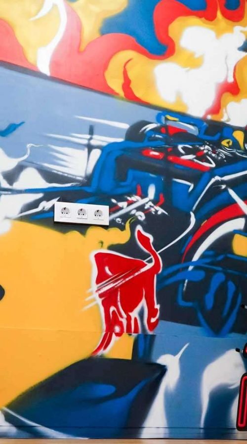Graffiti de Red Bull con F1 y llamas en espacio interior, mural con energía y acción