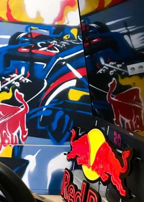 Graffiti de Red Bull con F1 y llamas en espacio interior, mural con energía y acción