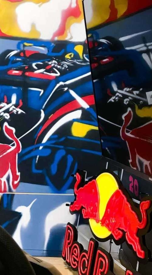 Graffiti de Red Bull con F1 y llamas en espacio interior, mural con energía y acción