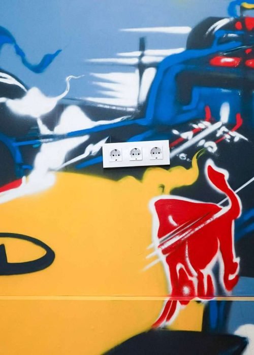 Graffiti de Red Bull con F1 y llamas en espacio interior, mural con energía y acción