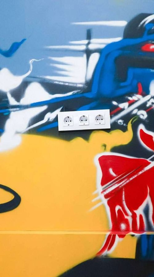 Graffiti de Red Bull con F1 y llamas en espacio interior, mural con energía y acción
