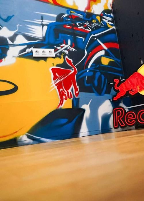 Graffiti de Red Bull con F1 y llamas en espacio interior, mural con energía y acción