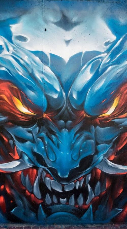 Graffiti de demonio japonés azul con ojos encendidos en Madrid