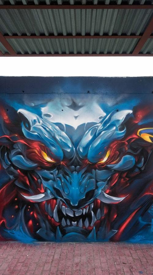 Graffiti de demonio japonés azul con ojos encendidos en Madrid