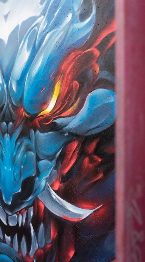 Graffiti de demonio japonés azul con ojos encendidos en Madrid