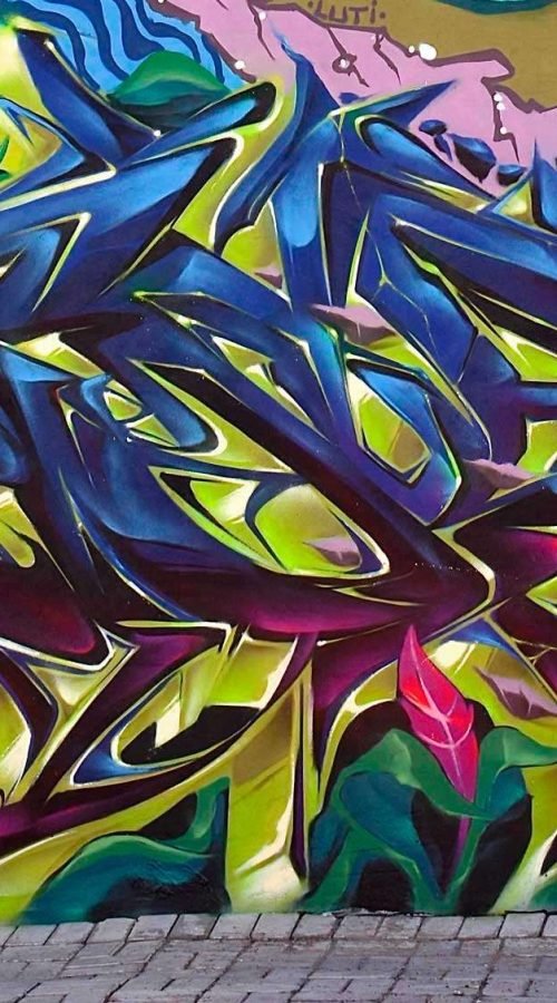 Mural de graffiti con letras en 3D y colores vivos en festival de Brasil