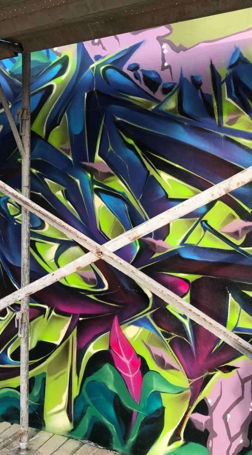 Mural de graffiti con letras en 3D y colores vivos en festival de Brasil