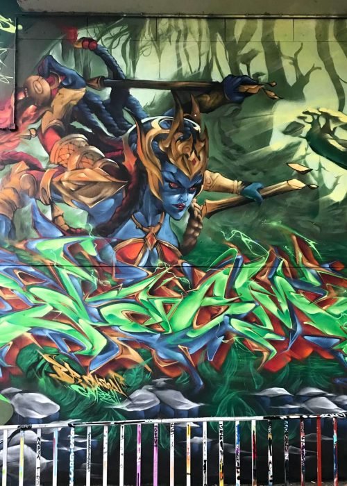 Graffiti de guerrera azul en un bosque con letras wildstyle. Festival Meeting Of Styles en Wiesbaden, Alemania